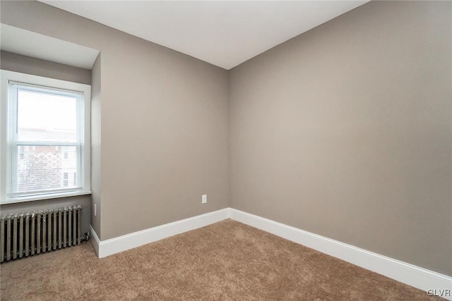 carpeted spare room with radiator heating unit