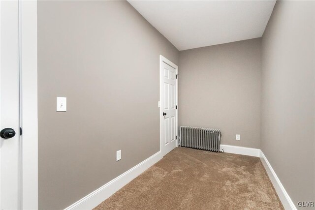 carpeted spare room featuring radiator