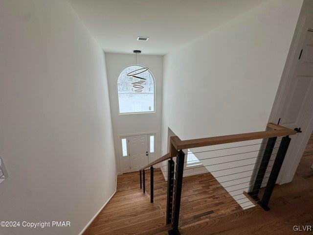 stairway with hardwood / wood-style floors