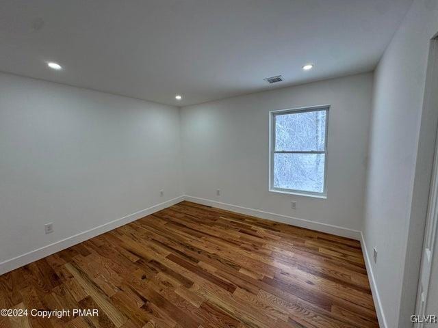 unfurnished room with hardwood / wood-style flooring