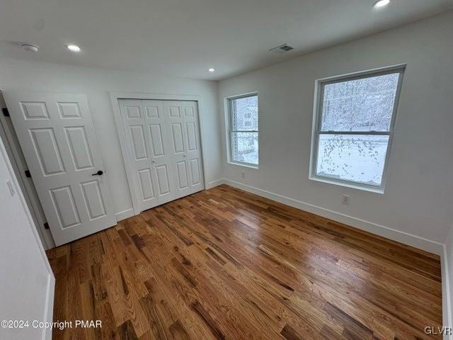 unfurnished bedroom with hardwood / wood-style flooring