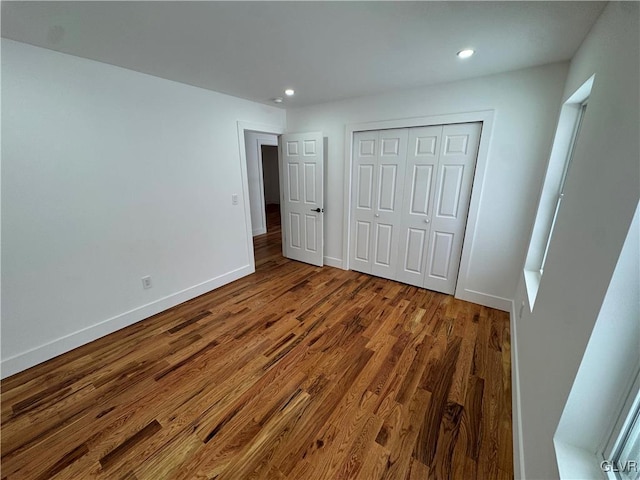 unfurnished bedroom featuring hardwood / wood-style flooring and a closet