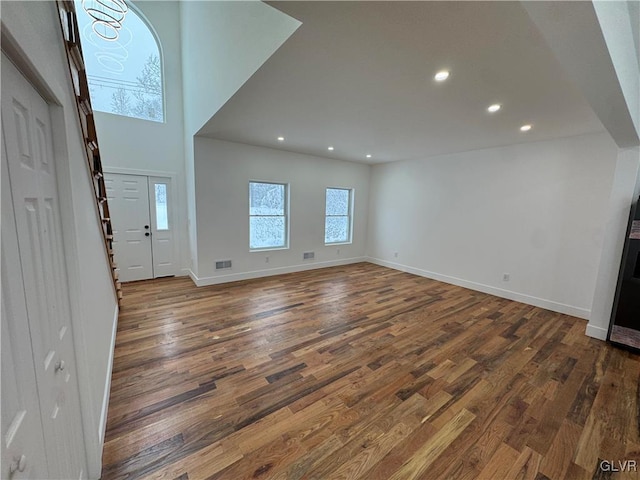 entryway with dark hardwood / wood-style floors and a high ceiling