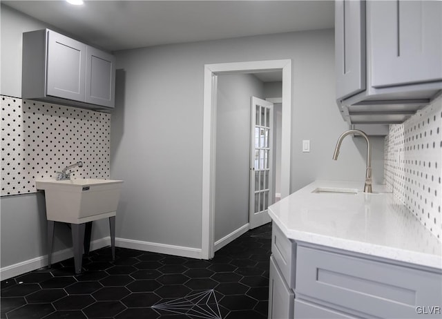 laundry area with dark tile patterned floors and sink