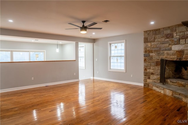 unfurnished living room featuring a fireplace, ceiling fan, and hardwood / wood-style floors