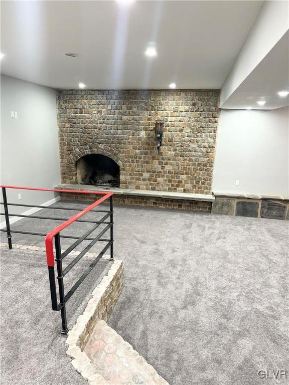 living room featuring carpet and a fireplace