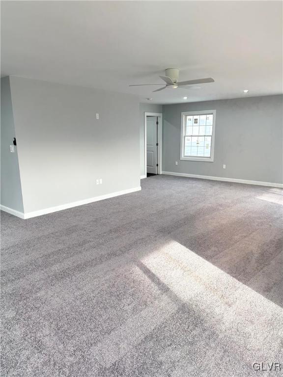 empty room featuring carpet flooring and ceiling fan