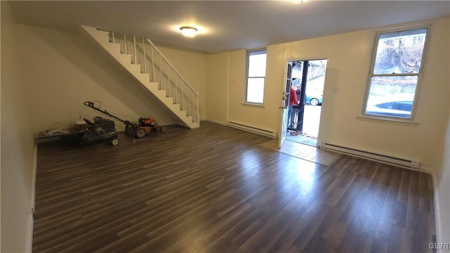 interior space with dark wood-type flooring and a baseboard heating unit