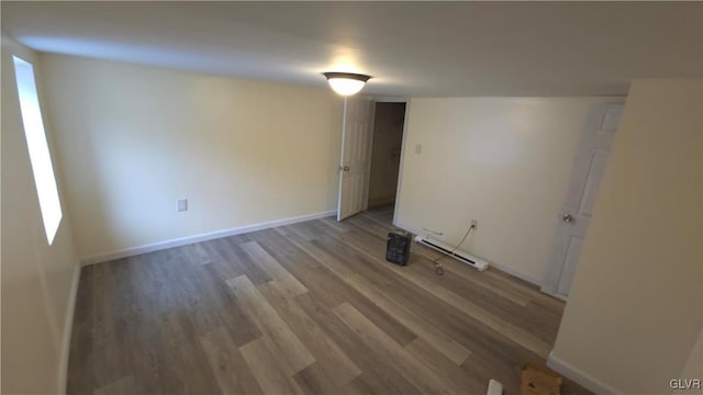 interior space with hardwood / wood-style floors and a baseboard heating unit