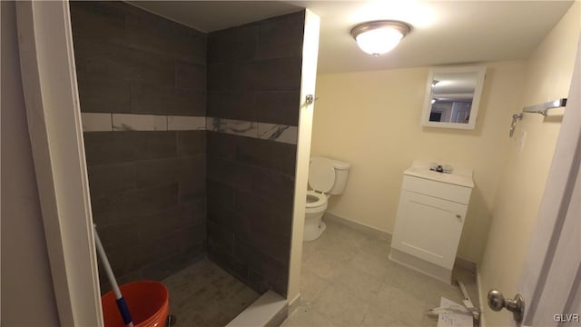 bathroom with a tile shower and toilet