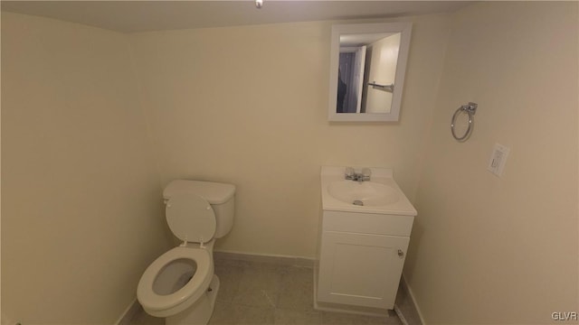 bathroom with tile patterned flooring, vanity, and toilet