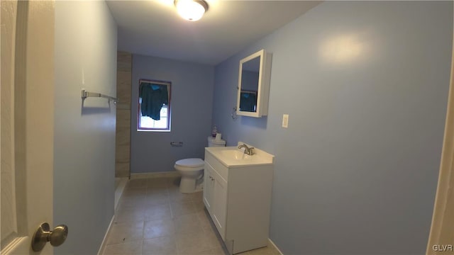 bathroom with toilet, vanity, and tile patterned floors