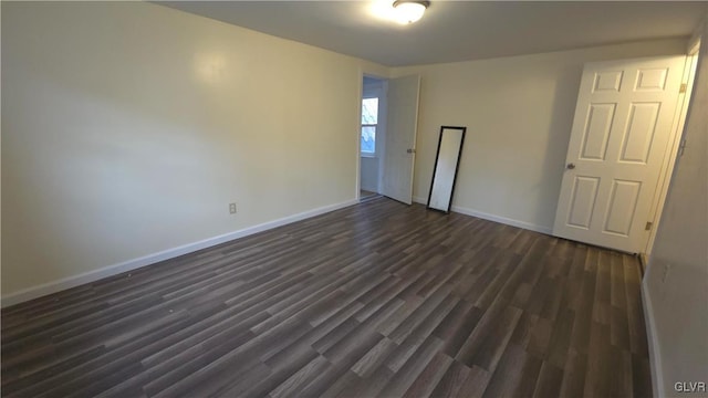 unfurnished room with dark hardwood / wood-style floors