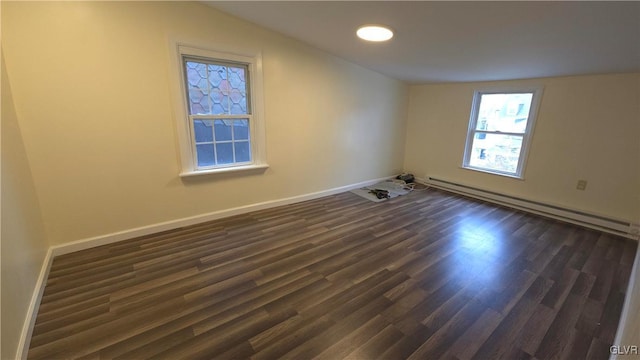 empty room with vaulted ceiling, dark wood-type flooring, and a baseboard radiator