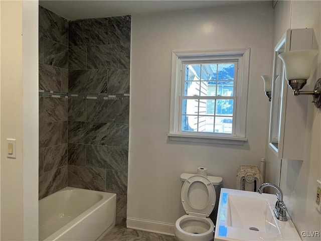 full bathroom featuring sink, tiled shower / bath combo, and toilet