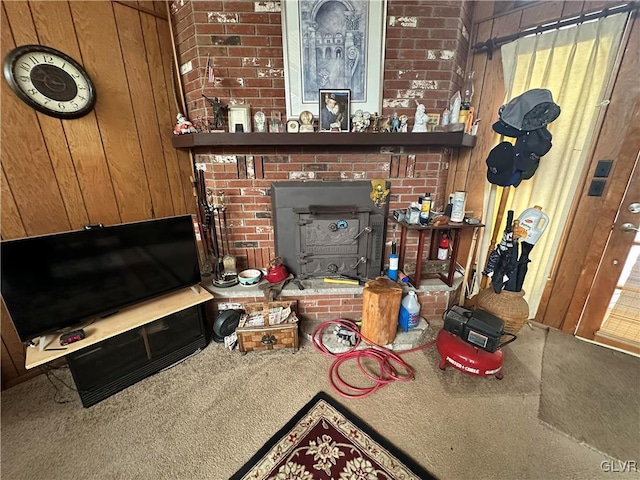 carpeted living room featuring a wood stove and wooden walls