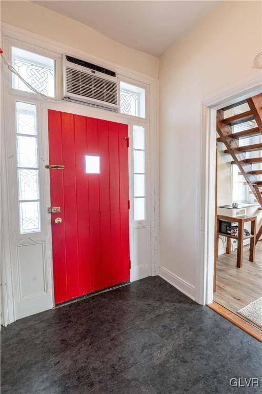 entryway featuring a healthy amount of sunlight, dark wood-type flooring, and a wall unit AC