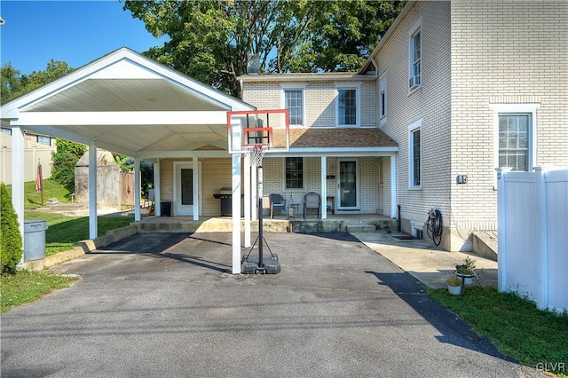 view of front of property featuring a porch, a shed, and a carport