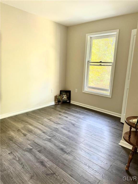 empty room with dark hardwood / wood-style flooring