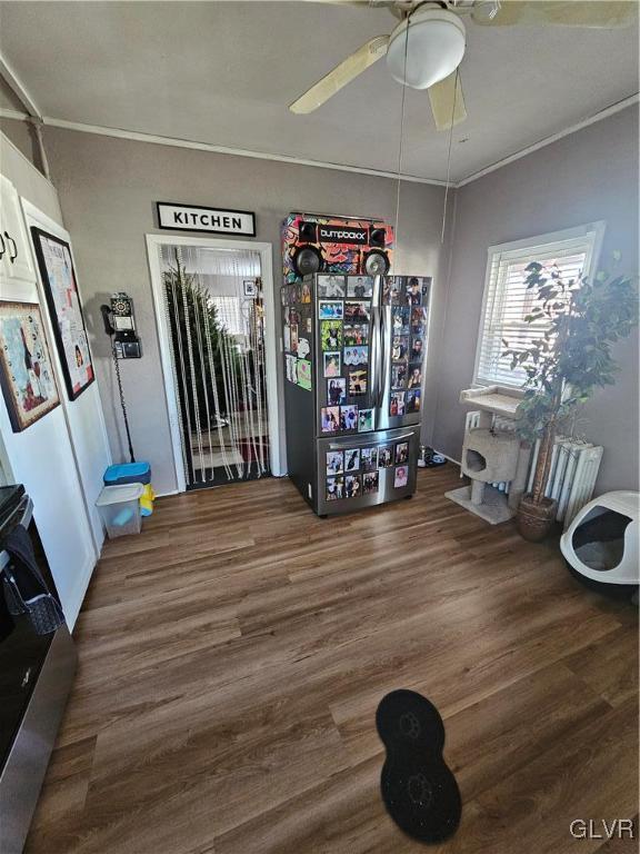 interior space featuring ceiling fan, crown molding, and dark hardwood / wood-style floors