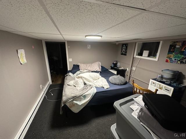 bedroom with a paneled ceiling and a baseboard radiator