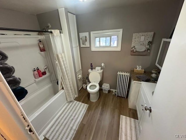 bathroom with shower / bath combo with shower curtain, radiator, hardwood / wood-style floors, and toilet