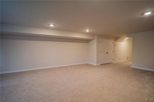 basement featuring light colored carpet