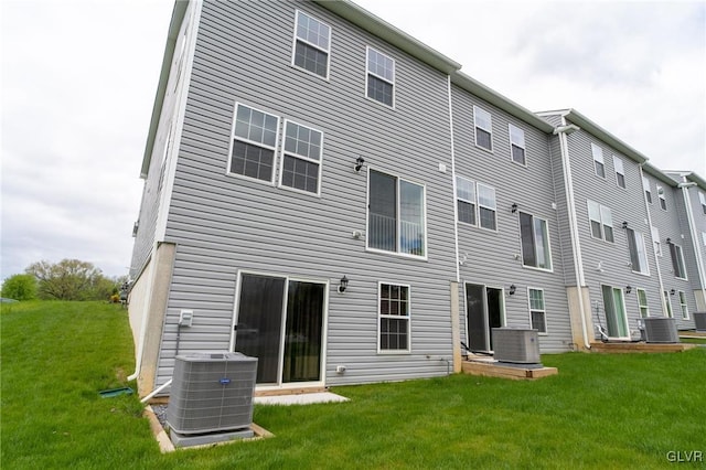 rear view of house featuring a yard and central AC unit