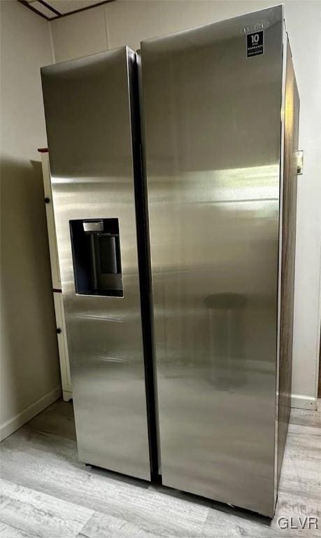 room details featuring stainless steel fridge with ice dispenser and light wood-type flooring