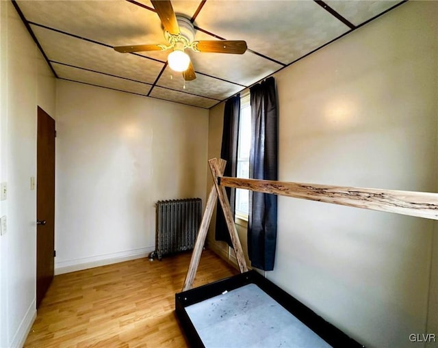 unfurnished bedroom featuring ceiling fan, light hardwood / wood-style flooring, and radiator heating unit