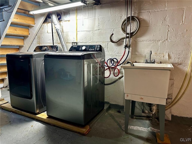 clothes washing area featuring sink and washer and clothes dryer