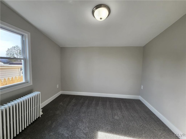 bonus room featuring dark carpet and radiator