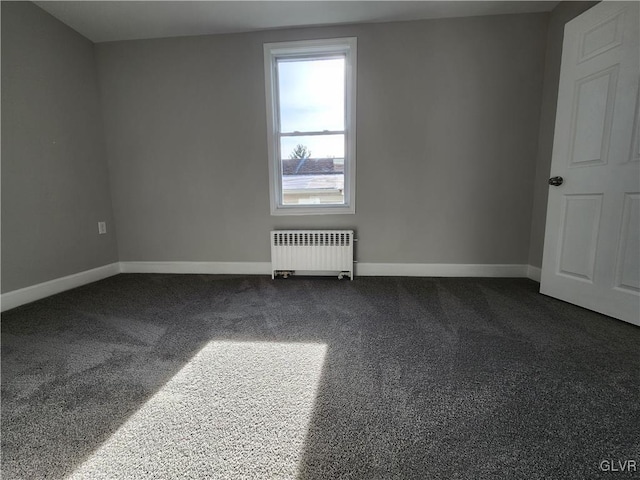 carpeted spare room featuring radiator