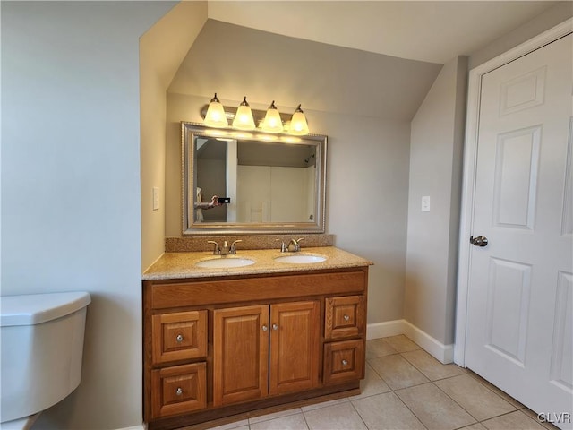 bathroom with tile patterned flooring, vanity, toilet, and lofted ceiling