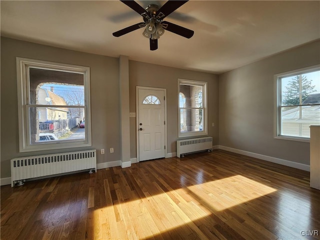 entrance foyer featuring hardwood / wood-style flooring, ceiling fan, and radiator heating unit