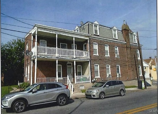 view of front of house with a balcony and covered porch