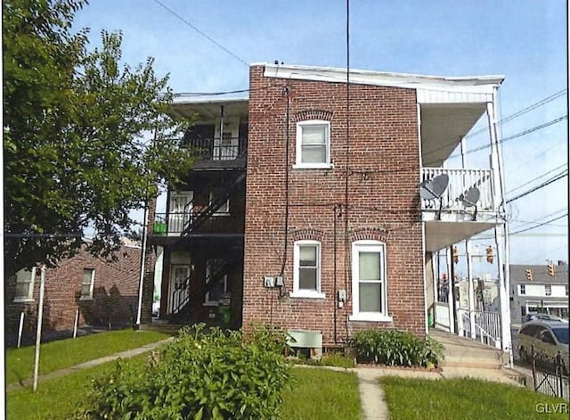 view of front of home with a front yard and a balcony