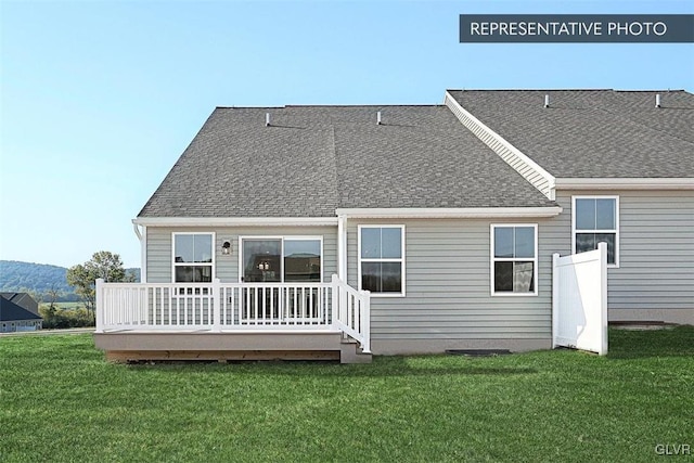 rear view of house with a lawn and a wooden deck