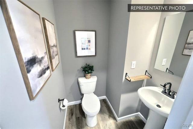 bathroom featuring hardwood / wood-style flooring, toilet, and sink