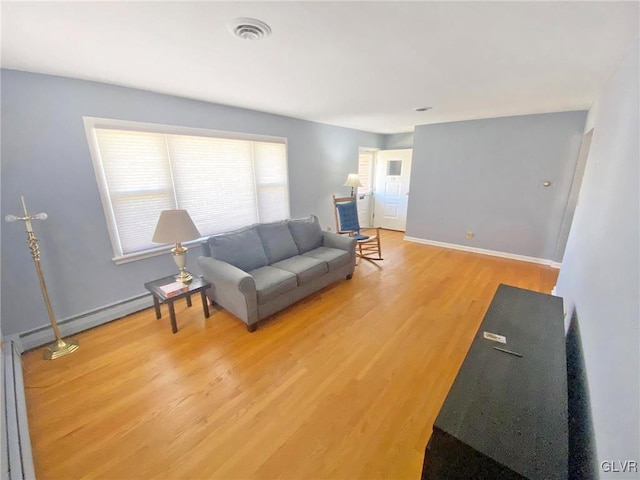 living room featuring light hardwood / wood-style floors and a baseboard heating unit