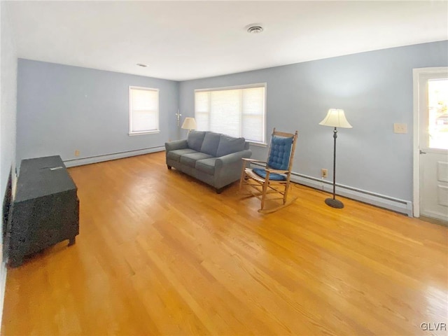 living area with plenty of natural light, a baseboard radiator, and light hardwood / wood-style flooring