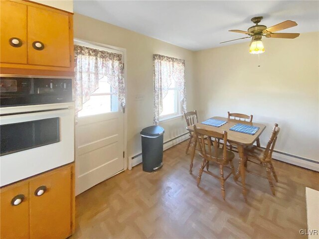 dining space featuring a baseboard radiator and ceiling fan