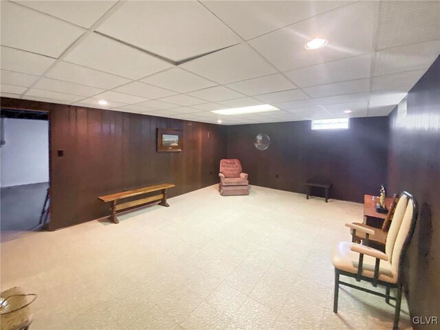 unfurnished room with a paneled ceiling and wooden walls