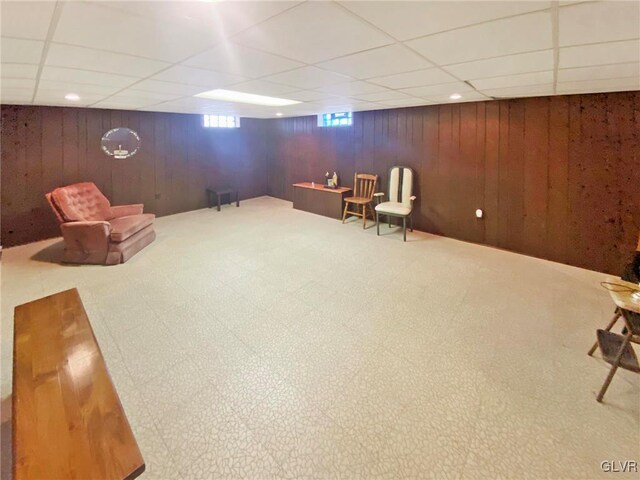 unfurnished room with a paneled ceiling and wood walls