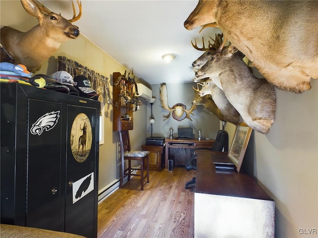 interior space featuring hardwood / wood-style floors, a baseboard radiator, and an AC wall unit