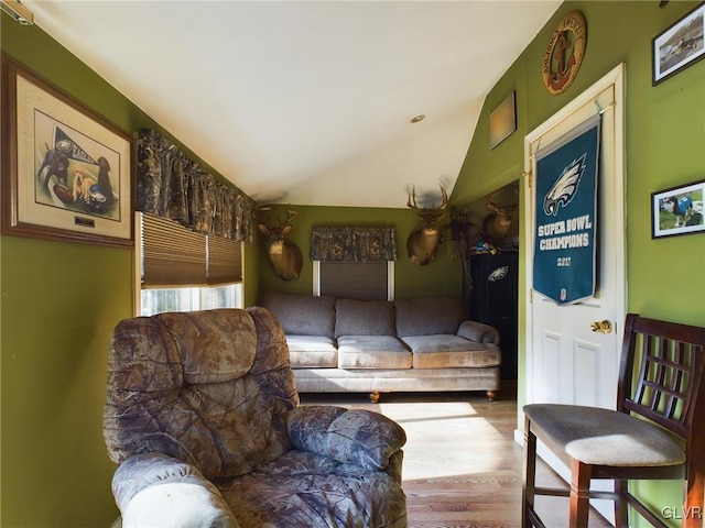 sitting room featuring wood-type flooring and vaulted ceiling