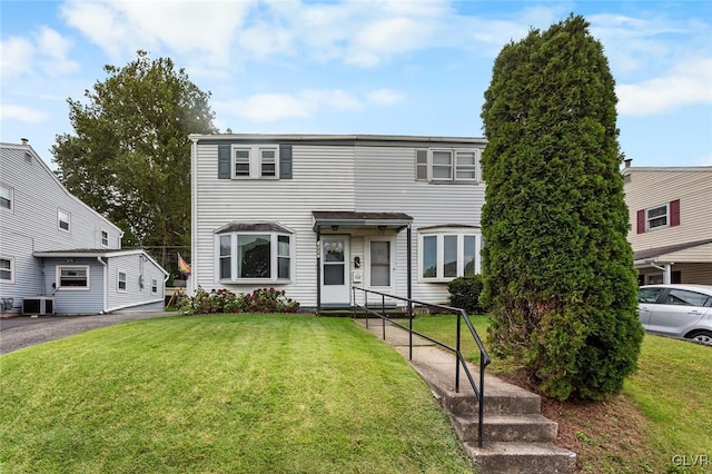 view of front of home featuring cooling unit and a front lawn