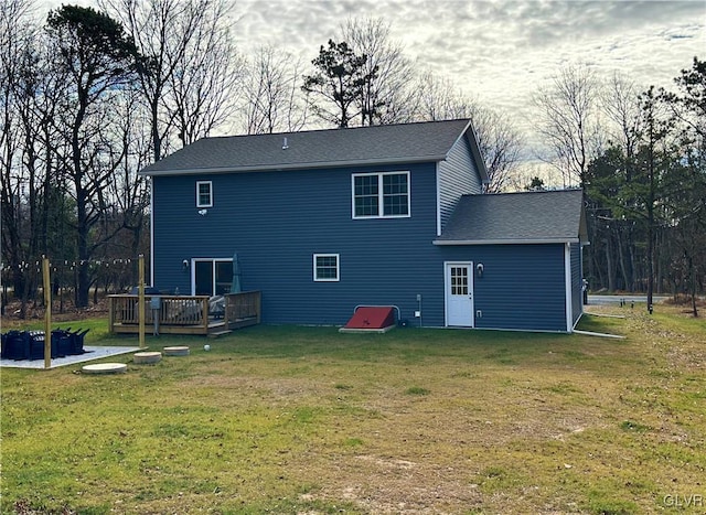 rear view of house featuring a wooden deck and a yard