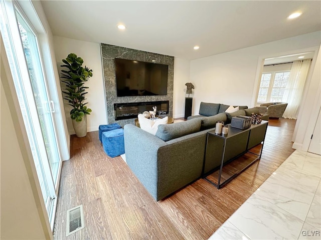 living room featuring a large fireplace and hardwood / wood-style flooring