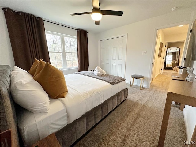 carpeted bedroom with ceiling fan and a closet